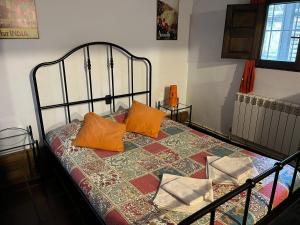a bed with orange pillows on it in a room at Fundalucia Guesthouse in Quéntar