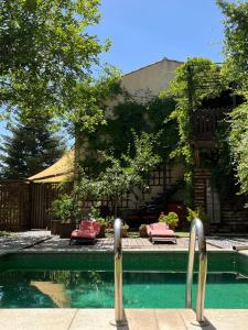 a swimming pool with two loungers in front of a building at Fundalucia Guesthouse in Quéntar +28 photos