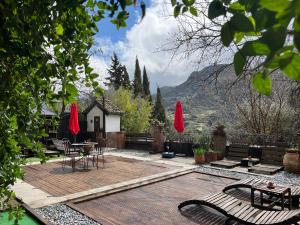 a patio with chairs and a table with a view at Fundalucia Guesthouse in Quéntar