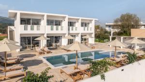 an aerial view of a hotel with a pool and umbrellas at Sinati Luxury Studios Laganas Zakynthos in Laganas