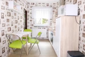 a small kitchen with green chairs and a table at Ferienwohnung Zur Rennsteigruh in Ruhla