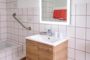 a bathroom with a sink and a mirror and a tub at Ferienwohnung Zur Rennsteigruh in Ruhla +7 photos