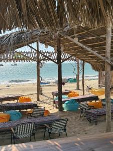 a beach with chairs and tables and the ocean at Homestay JB Sơn Hải in Thôn Sơn Hải