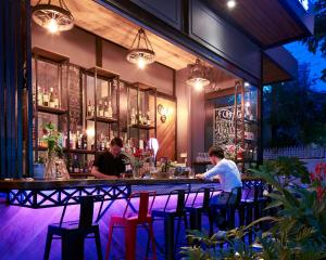 dos hombres sentados en un bar en un restaurante en Monsoon Bassac Hotel en Phnom Penh