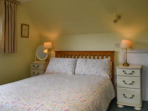 a bedroom with a bed with two night stands and two lamps at Gwel An Lowarth in Lostwithiel +10 photos
