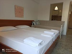 a bedroom with a large white bed with towels on it at Rooms To Let Giannis in Makrygialos +10 photos