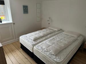 zwei Einzelbetten in einem Schlafzimmer mit Fenster in der Unterkunft Plads til 5 in Samsø