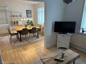 ein Wohnzimmer mit Esstisch und Fernseher in der Unterkunft Plads til 5 in Samsø