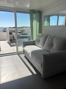 a living room with a couch and a view of a patio at Sunset in Cap d'Agde +1 photo