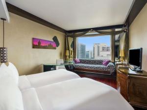 a hotel room with two beds and a couch at Sofitel Mumbai BKC in Mumbai