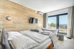 a bedroom with two beds and a tub and a television at Villa Luca in Seget Vranjica +63 photos
