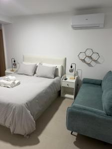 a white bedroom with a bed and a couch at Jupiter 4 dormitorios 300 depósito in Alcorcón