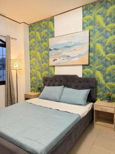 a bedroom with a bed with a painting on the wall at Villa de Flynn Private Resort in Bauang +14 photos