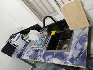 a kitchen counter top with a sink in a room at Canelle appart tout équipé et lumineux in Dzaoudzi