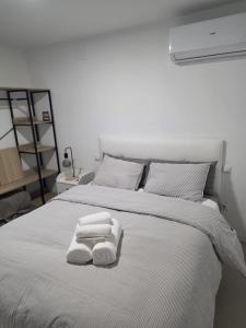 a bedroom with a white bed with towels on it at Jupiter 4 dormitorios 300 depósito in Alcorcón +4 photos