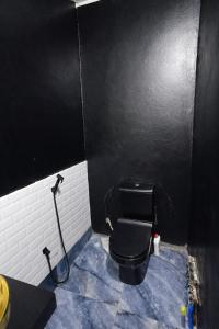 a black and white bathroom with a black toilet at Canelle appart tout équipé et lumineux in Dzaoudzi