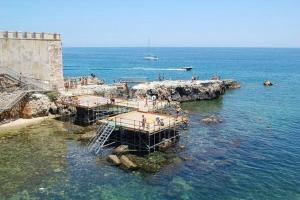 a group of people standing on a pier in the water at Donna Sicilia Ortigia in Syracuse +3 photos