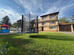 a trampoline in a yard in front of a house at Helena Guest House - Pool & Sea View in Balchik