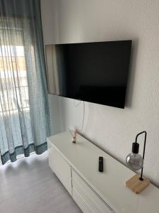 a flat screen tv on a wall with a white dresser at JP House in Figueira da Foz