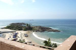 a view of a beach with people and the ocean at Hotel Searock in Trivandrum