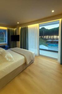 a bedroom with a bed and a large window at Vila Eva in Golem