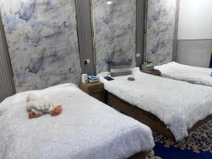 a room with two beds with a teddy bear on them at فله مع حديقه in Mukhaylīf