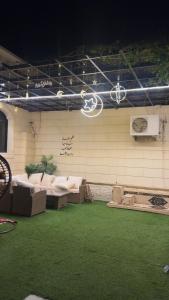 a patio with couches and a wall with green grass at فله مع حديقه in Mukhaylīf