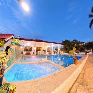 a swimming pool in front of a house at Villa de Flynn Private Resort in Bauang