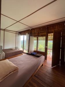 a bedroom with two beds and a large window at Sapan Goodview สะปันกู๊ดวิว in Ban Na Luang