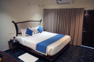 a bedroom with a large bed with blue pillows at Hotel Searock in Trivandrum +19 photos