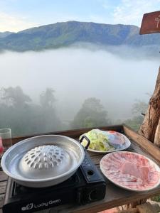 a grill with three plates of food on a table with a view at Sapan Goodview สะปันกู๊ดวิว in Ban Na Luang