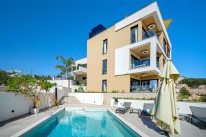 a villa with a swimming pool and a house at Villa Luca in Seget Vranjica