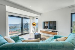a living room with a blue couch and large windows at Villa Luca in Seget Vranjica