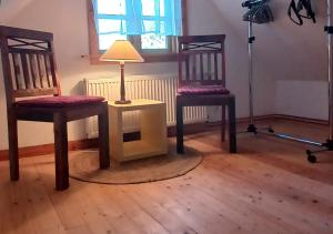 two chairs and a table with a lamp in a room at Ferienhaus Oppeln 21 in Wingst