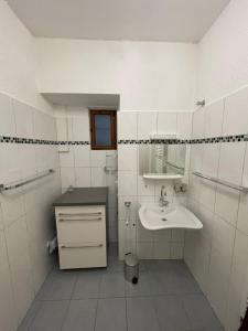 a white bathroom with a sink and a mirror at Ferienwohnung Moselsteig in Reil