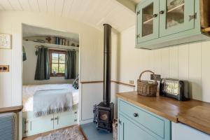 a small kitchen with a stove in a tiny house at Hurdlemakers Hut in Dorchester +12 photos