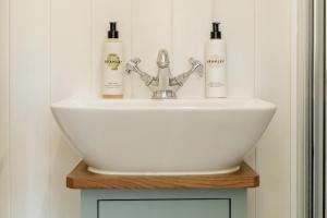 a bathroom sink with three bottles on top of it at Hurdlemakers Hut in Dorchester