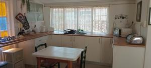 a kitchen with a table and a small kitchen with a sink at Wiltshire Cottage in Port Alfred
