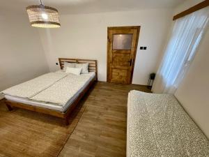 a bedroom with two beds and a door at Chaloupka na Perkách in Zahrádky