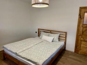 a bedroom with a bed and a chandelier at Chaloupka na Perkách in Zahrádky