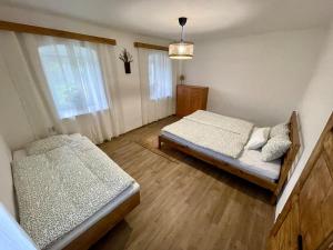 a bedroom with two beds and a window at Chaloupka na Perkách in Zahrádky +17 photos