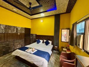 a bedroom with a bed and a yellow wall at Amber Palace in Varanasi