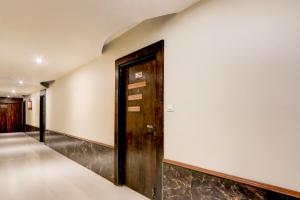 a hallway with a wooden door and a wall at Super Townhouse Oak Madhapur Nera Regency in Hyderabad
