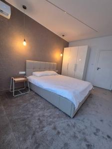 a bedroom with a large white bed and a table at Апартамент Top Central in Yambol +4 photos