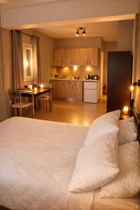 a bedroom with a white bed and a kitchen at Rodanthy II in Katelios
