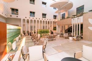 a lobby of a hotel with chairs and tables at Hasanah Suites Serviced Apartment- شقق أجنحة حسنة للشقق المخدومة in Medina