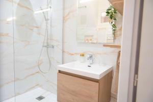 a bathroom with a sink and a shower at Triplex Chic au Cœur de Valence in Valence