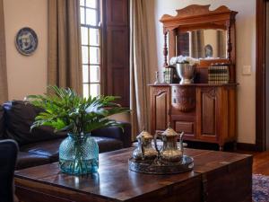 a living room with a coffee table and a mirror at Meerendal Boutique Hotel in Durbanville