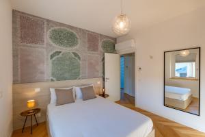 a bedroom with a large white bed and a mirror at Residence Moretti in Udine