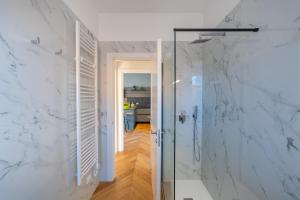 a bathroom with a shower with white marble walls at Residence Moretti in Udine +40 photos